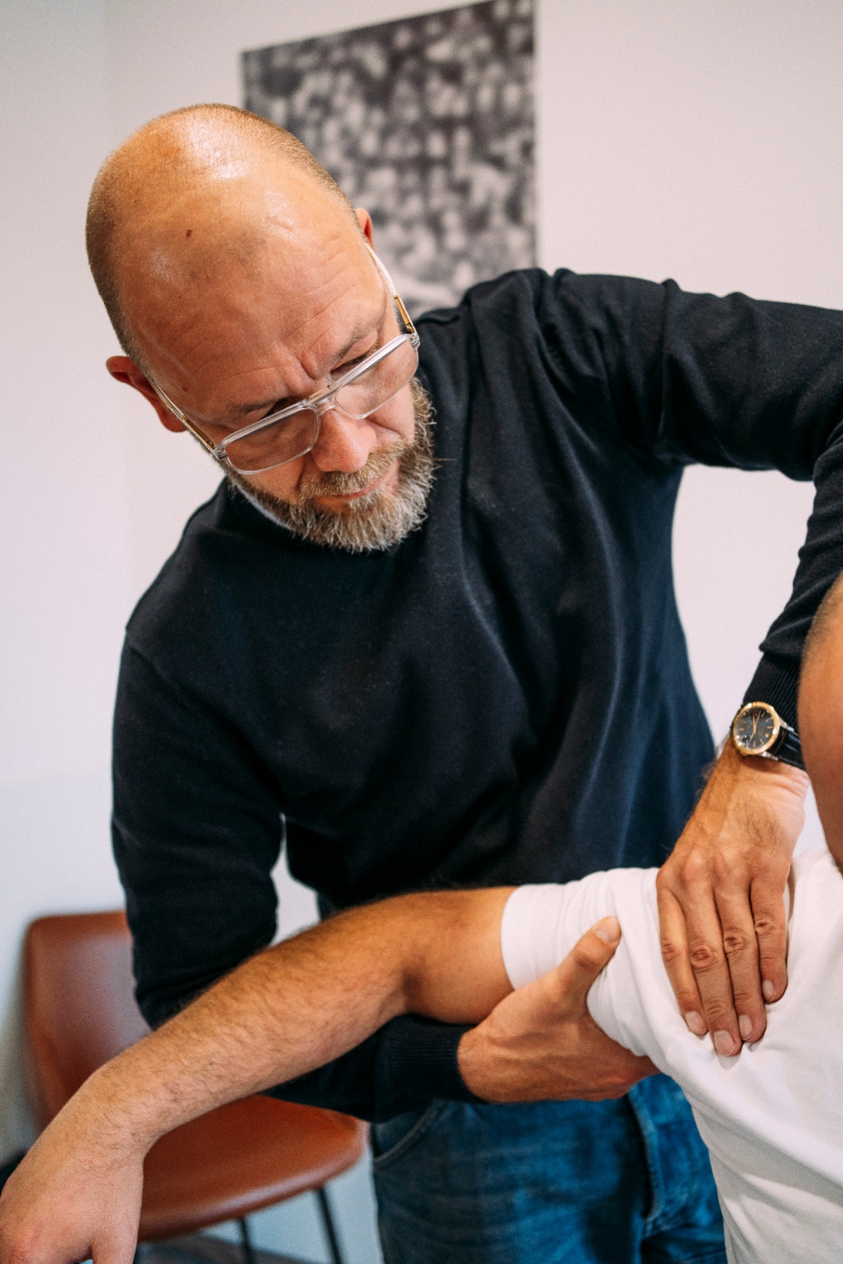 Tobi mobilisiert Schulter eines Patienten